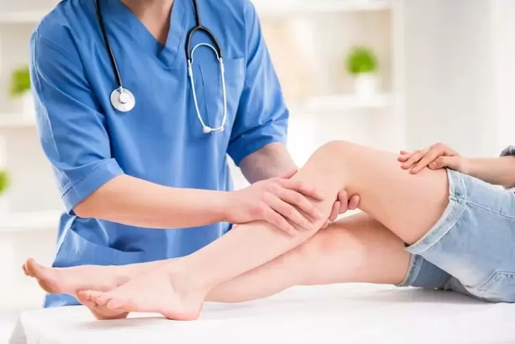the doctor examines the leg with varicose veins
